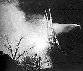 Brennender Kirchturm am 08.12.1999. Von der rechten Seite versucht ein Feuerwehrmann vergeblich den Brand zu lschen.